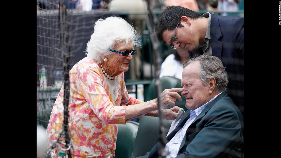 Barbara Bush puts some sunscreen on her husband&#39;s nose as they get ready to watch the Seattle Mariners play the Houston Astros in a Major League Baseball game on May 3, 2015.