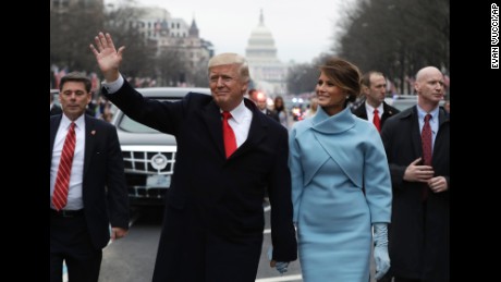 President Donald Trump waves as he walks with first lady Melania Trump during the inauguration parade on Pennsylvania Avenue in Washington, Friday, Jan. 20, 2016. (AP Photo/Evan Vucci, Pool)