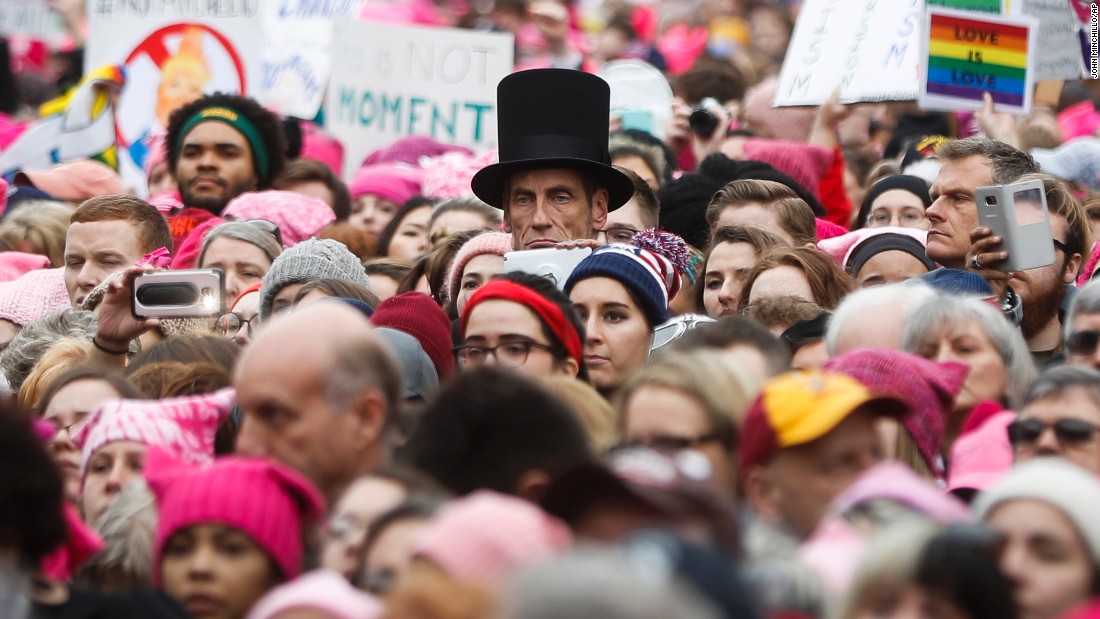 A man dressed as Abraham Lincoln stands with protesters.