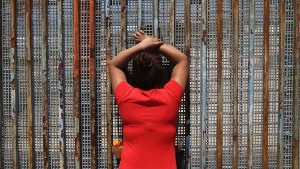 TIJUANA, MEXICO - MAY 01:  Gabriella Ramirez, 23, speaks to her boyfriend, a construction worker who immigrated to California, through the U.S.-Mexico border fence on May 1, 2016 in Tijuana, Mexico. Mexicans on the Tijuana side can approach the border fence at any time. The U.S. Border Patrol, however, tightly controls the San Diego, CA side and allows visitors to speak to loved ones through the fence during restricted weekend hours at "Friendship Park". The park is the only place along the 1,954-mile border where such interactions are permitted by U.S. authorities. On only three occassions have U.S. officials allowed a gate to be opened at the park for pre-screened separated family members to embrace.  (Photo by John Moore/Getty Images)