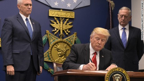 US President Donald Trump signs an executive order alongside US Defense Secretary James Mattis and US Vice President Muike Pence on January 27, 2016 at the Pentagon in Washington, DC.
Trump signed an order Friday to begin what he called a &quot;great rebuilding&quot; of the US armed services, promising new aircraft, naval ships and more resources for the military. &quot;Our military strength will be questioned by no one, but neither will our dedication to peace. We do want peace,&quot; Trump said in a ceremony at the Pentagon.
 / AFP / MANDEL NGAN        (Photo credit should read MANDEL NGAN/AFP/Getty Images)