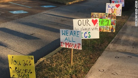 Neighbors put up signs to make refugee students feel welcome after Trump executive order.