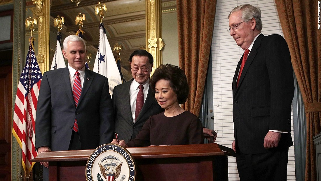 Elaine Chao, Trump&#39;s pick for transportation secretary, signs the affidavit of appointment during her swearing-in ceremony in Washington on Tuesday, January 31. Chao is joined, from left, by Pence; her father, James Chao; and her husband, Senate Majority Leader Mitch McConnell.