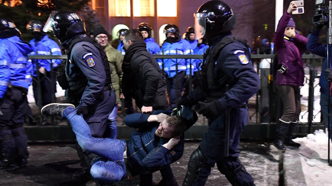 Anti-riot police remove a protester February 1 in front of government headquarters in Bucharest.