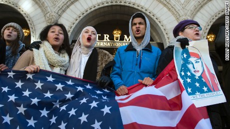 Protesters hold an US Flag while protesting outside the Trump Hotel on February 4, 2017, in Washington, DC. The demonstrators protested US President Donald Trump&#39;s travel ban on nationals from seven Muslim-majority countries. 