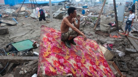 A man rests by his destroyed home in the devasted area of Beijing in July 2012, after severe flooding.