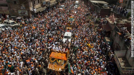 VARANASI, INDIA - APRIL 24:  BJP leader Narendra Modi waves to supporters as he rides in an open truck on his way to filing his nomination papers on April 24, 2014 in Varanasi, India. India is in the midst of a nine phase election that began on April 7 and ends May 12.  (Photo by Kevin Frayer/Getty Images)
