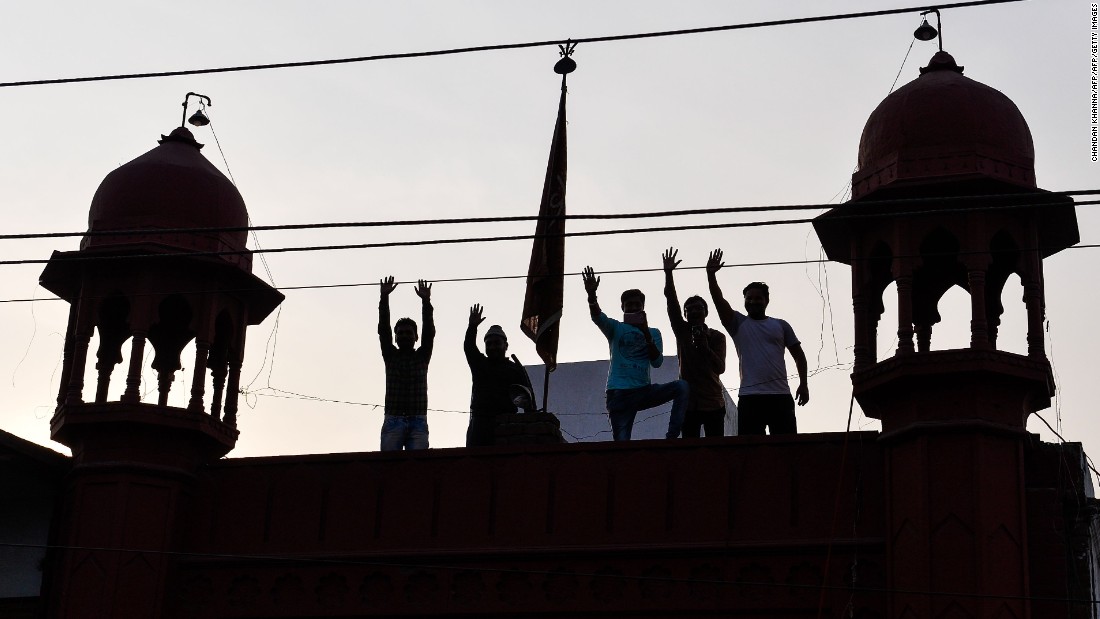 Supporters wave from a rooftop as they attend a joint election campaign rally by Chief Minister, Akhilesh Yadav, and Congress party vice president, Rahul Gandhi, in February 2017. 