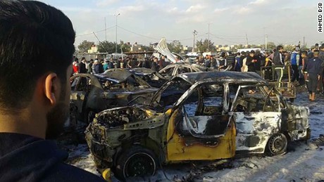A burned-out car sits at the site of a deadly bombing Thursday in Baghdad.
