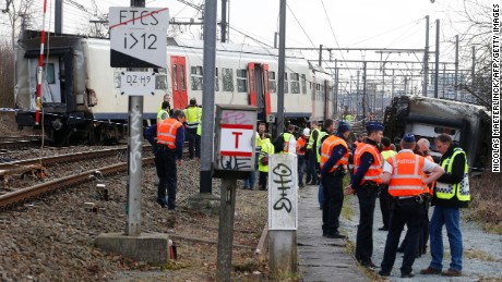 Police officers and officials stand next to a train after it derailed Saturday in Leuven, east of Brussels.