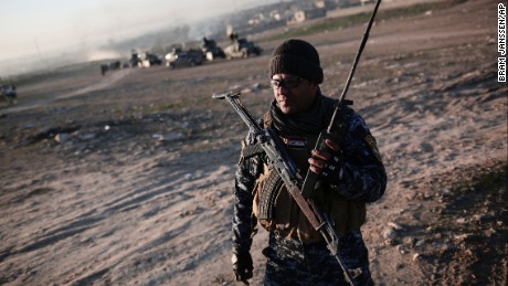 A member of the Iraqi federal police operates a radio in the town of Hamam al-Alil on Sunday as Iraqi forces begin the offensive against ISIS in western Mosul.