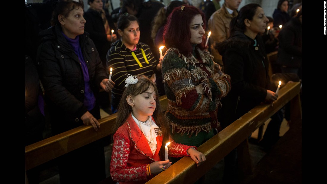 A young girl takes part in a Christmas Day Mass at a church in the predominantly Christian town of Qaraqosh. The area&#39;s churches were heavily damaged by ISIS militants before the town was freed by Iraqi forces during the Mosul offensive.