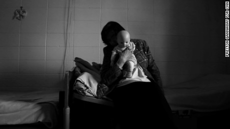 An alleged victim snuggles with a doll she calls Little Missy in her room at a nursing home facility in Haywood County.