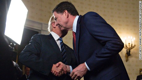 WASHINGTON, DC - JANUARY 22: U.S. President Donald Trump (L) shakes hands with James Comey, director of the Federal Bureau of Investigation (FBI), during an Inaugural Law Enforcement Officers and First Responders Reception in the Blue Room of the White House on January 22, 2017 in Washington, DC. Trump today mocked protesters who gathered for large demonstrations across the U.S. and the world on Saturday to signal discontent with his leadership, but later offered a more conciliatory tone, saying he recognized such marches as a &quot;hallmark of our democracy.&quot; (Photo by Andrew Harrer-Pool/Getty Images)