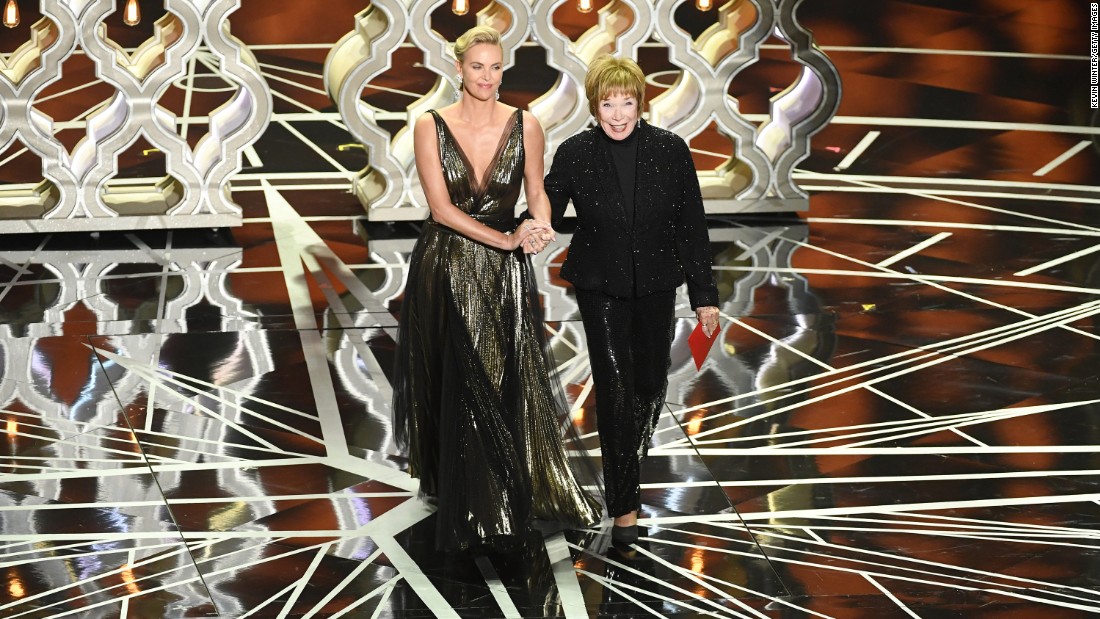 Charlize Theron, left, and Shirley MacLaine walk on stage to present an award. Theron said MacLaine inspired her to get into acting.