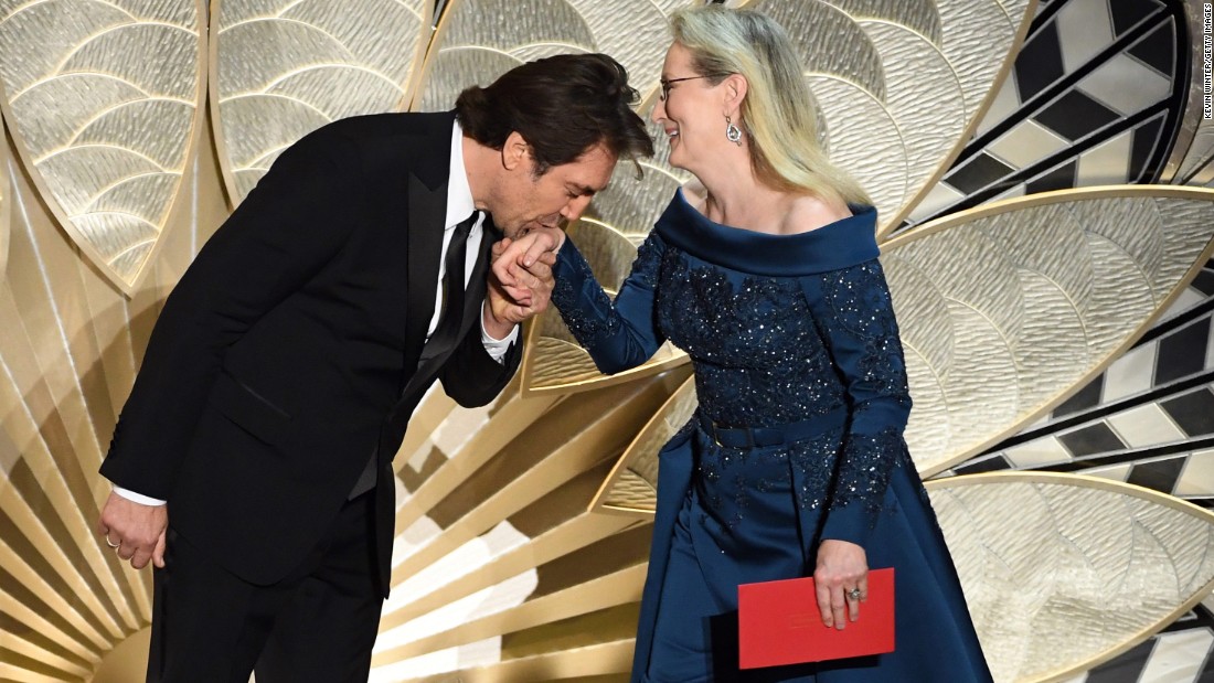 Javier Bardem kisses Meryl Streep&#39;s hand as they present an award.