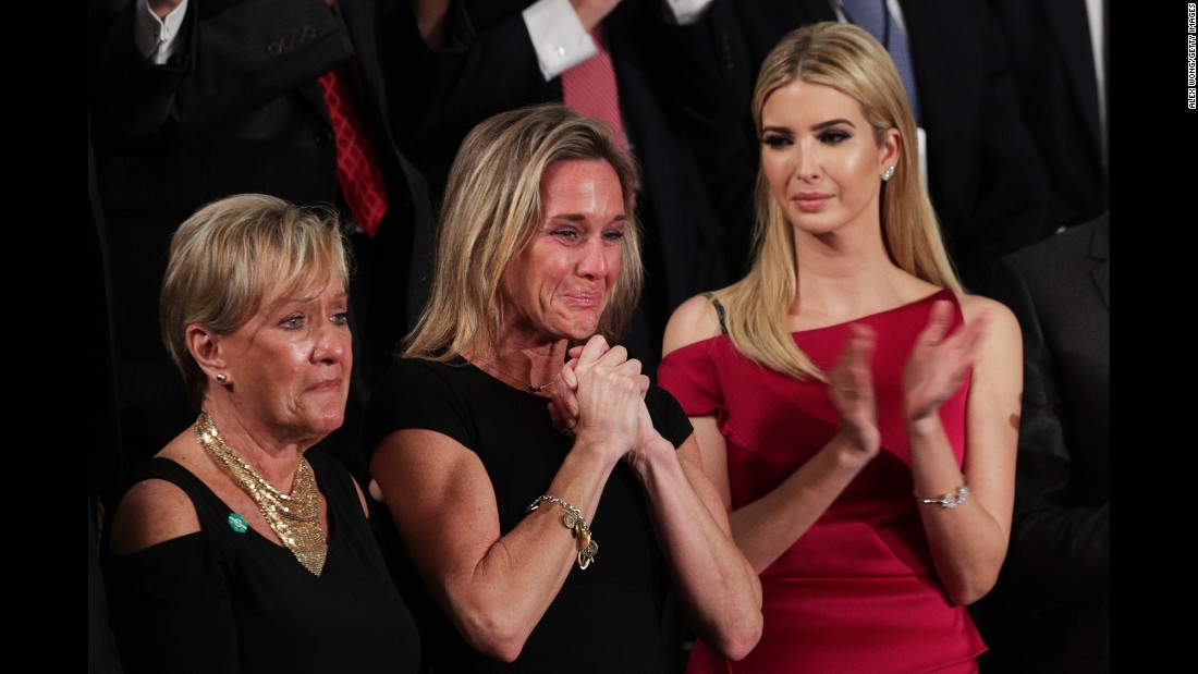 Carryn Owens, center, cries as she is applauded by the chamber during Trump&#39;s speech. Owens&#39; husband, Navy SEAL William &quot;Ryan&quot; Owens, recently was killed during a mission in Yemen. &quot;Ryan died as he lived: a warrior and a hero, battling against terrorism and securing our nation,&quot; Trump said. The applause lasted over a minute, which Trump said must be a record.