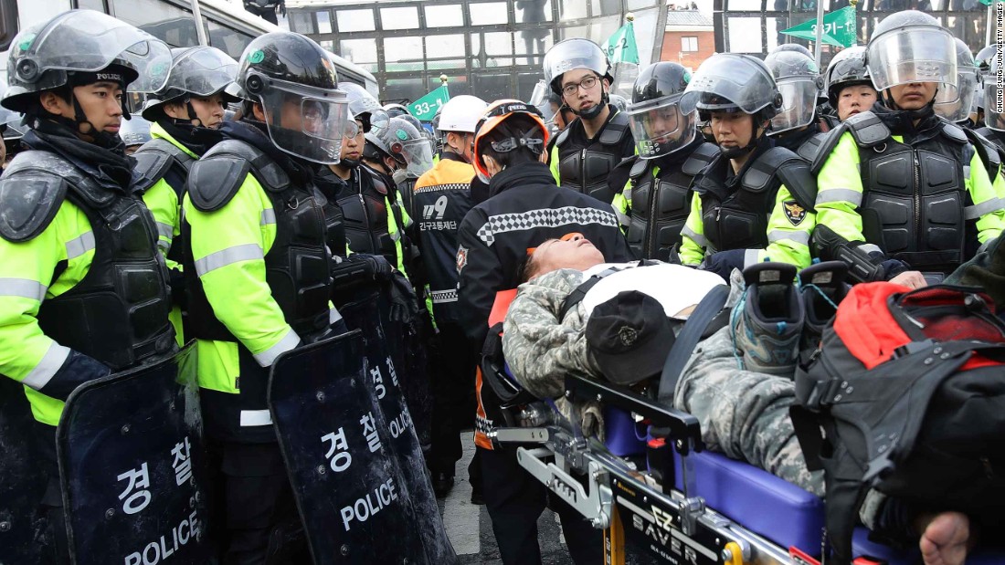 An injured Park supporter lies on a stretcher surrounded by police.