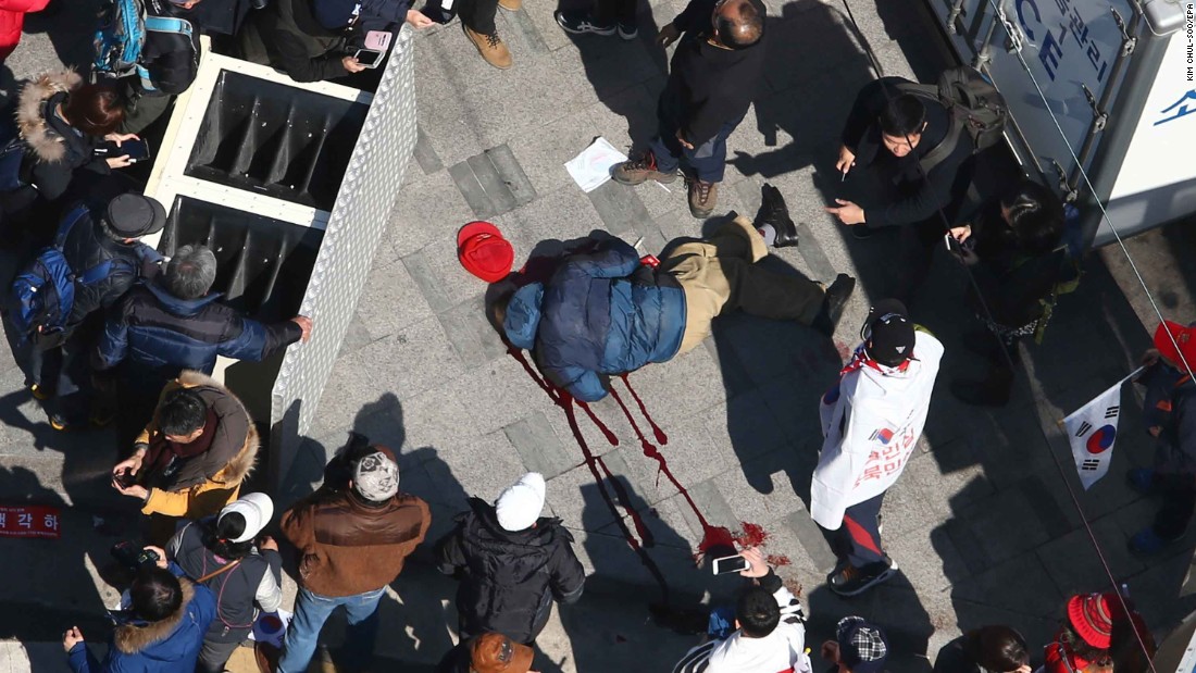 A supporter of the ousted president lies in a pool of blood as protesters push to pass a police barricade preventing them from reaching the Constitutional Court. According to police, two people died in the protests. A statement from acting President Hwang Kyo-ahn said several people also were injured.
