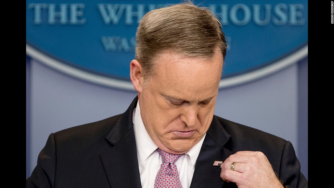 White House press secretary Sean Spicer adjusts his American flag pin after he was told that it was upside down on Friday, March 10.