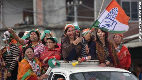 Supporters of India&#39;s Congress wave their flags as they celebrate their candidate&#39;s win in state assembly elections in Imphal on March 11.