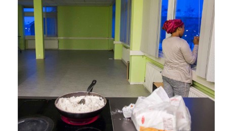 A woman from We Are Here speaks on the phone while cooking at the women&#39;s building in Amsterdam west.
