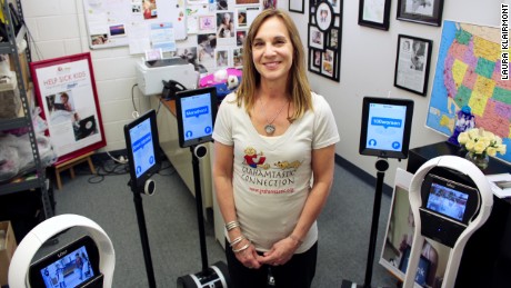 CNN Hero Leslie Morissette poses with some of the robots her nonprofit, Grahamtastic Connection, provides to ill schoolchildren to help them stay connected to the classroom and to their peers.