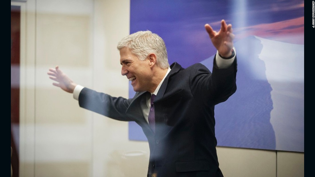 Gorsuch, seen through glass, speaks with staff members before meeting with US Sen. Tom Udall, D-New Mexico, on February 27.