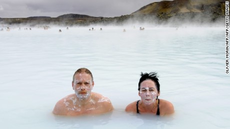 Tourists stand in the Blue Lagoon outside Reykjavik on 26 April, 2009. The Blue Lagoon&#39;s blue and green waters come from natural hot water springs flowing through rocks of lava. The  lagoon might have some health properties. AFP PHOTO OLIVIER MORIN. (Photo credit should read OLIVIER MORIN/AFP/Getty Images)