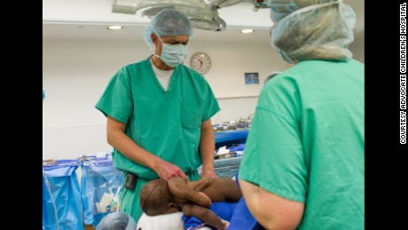 El neurocirujano pediátrico Dr. John Ruge examina a Baby Dominique antes de la cirugía