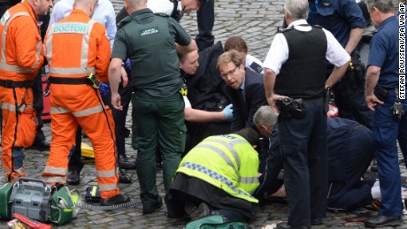 Conservative Member of Parliament Tobias Ellwood, centre, helps emergency services attend to an injured person outside the Houses of Parliament, London, Wednesday, March 22, 2017.  London police say they are treating a gun and knife incident at Britain&#39;s Parliament &quot;as a terrorist incident until we know otherwise.&quot; The Metropolitan Police says in a statement that the incident is ongoing. It is urging people to stay away from the area. Officials say a man with a knife attacked a police officer at Parliament and was shot by officers. Nearby, witnesses say a vehicle struck several people on the Westminster Bridge.  (Stefan Rousseau/PA via AP).