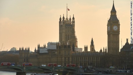 A picture shows red London buses, pedestrians and traffic crossing Westminster Bridge over the River Thames with the Union flag atop the Houses of Parliament (R) flying at half-mast in central London on March 23, 2017. 
Britain&#39;s parliament reopened on Thursday with a minute&#39;s silence in a gesture of defiance a day after an attacker sowed terror in the heart of Westminster, killing three people before being shot dead. Sombre-looking lawmakers in a packed House of Commons chamber bowed their heads and police officers also marked the silence standing outside the headquarters of London&#39;s Metropolitan Police nearby.
 / AFP PHOTO / Niklas HALLE&#39;N        (Photo credit should read NIKLAS HALLE&#39;N/AFP/Getty Images)