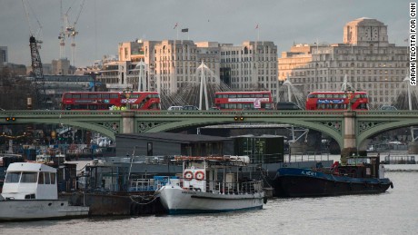 Police and forensics officers investigate near buses abandoned on Westminster Bridge following a terror attack on March 22.
