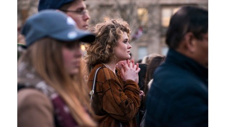 Kit Keane, 19, an American student at King&#39;s College London, clasps her hands as the vigil begins.
