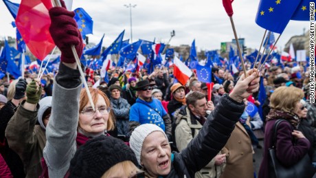 People wave EU and Polish flags Saturday in Warsaw on the 60th anniversary of the Treaty of Rome.