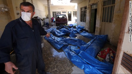 An Iraqi rescue worker gestures towards bodies wrapped in plastic in the Mosul al-Jadida area on March 26, 2017, following air strikes in which civilians have been reportedly killed during an ongoing offensive against the Islamic State group.  
Iraq is investigating air strikes in west Mosul that reportedly killed large numbers of civilians in recent days, a military spokesman said.