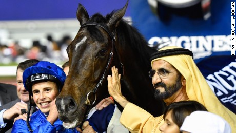 UAE Prime Minister and Ruler of Dubai Sheikh Mohammed bin Rashid al-Maktoum (C-R) celebrates with Jockey William Buick (C-L) and horse Jach Hobbs (C) after they won the Longines Dubai Sheema Classic at the Dubai World Cup in the Meydan Racecourse on March 25, 2017 in Dubai. / AFP PHOTO / Abdulqader  AL-ANI        (Photo credit should read ABDULQADER  AL-ANI/AFP/Getty Images)