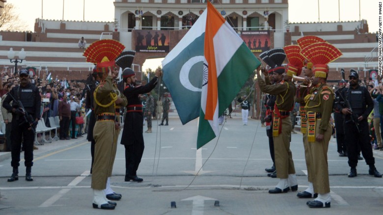 Pakistani Rangers and Indian Border Security Force personnel fold their respective national flags as they perform during the daily beating of the retreat ceremony on the India-Pakistan Border at Wagah on February 20, 2017.