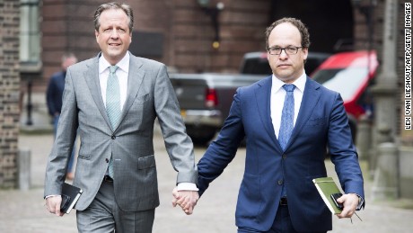 Alexander Pechtold (L) and Wouter Koolmees of the D66 party arrive for a political meeting, holding hands in solidarity with a gay couple.
