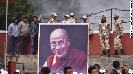 Indian security personnel stand being a poster of exiled Tibetan spiritual leader the Dalai Lama as he delivers religious teachings at the Buddha Stadium in Bomdila in India&#39;s north-eastern state of Arunachal Pradesh state on April 5, 2017.
The Dalai Lama is visiting the northeast Indian state of Arunachal Pradesh, where he first crossed into the country, and where he is scheduled to hold a series of teachings. / AFP PHOTO / Biju BORO        (Photo credit should read BIJU BORO/AFP/Getty Images)