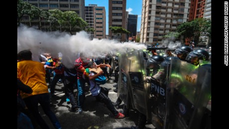 TOPSHOT - Venezuela's opposition activists clash with riot police agents during a protest against Nicolas Maduro's government in Caracas on April 4, 2017.
Protesters clashed with police in Venezuela Tuesday as the opposition mobilized against moves to tighten President Nicolas Maduro's grip on power. Protesters hurled stones at riot police who fired tear gas as they blocked the demonstrators from advancing through central Caracas, where pro-government activists were also planning to march.
 / AFP PHOTO / JUAN BARRETO        (Photo credit should read JUAN BARRETO/AFP/Getty Images)
