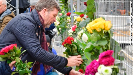 People lay flowers Saturday at the scene of a truck attack in central Stockholm.