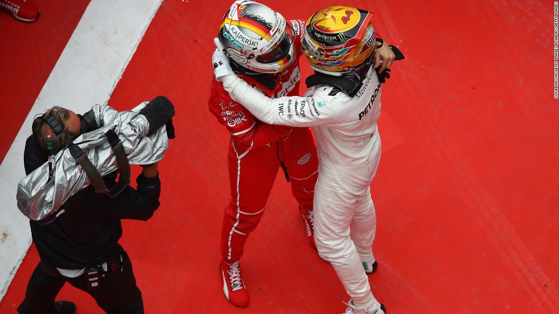 Race winner Hamilton (right) embraces Sebastian Vettel of Ferrari who finished second.