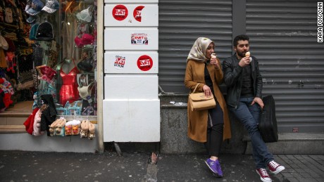 A couple in Istanbul&#39;s city center on Sunday, April 9, perch on a street adorned with stickers that say &quot;Evet&quot; -- the symbol for the &quot;Yes&quot; campaign.