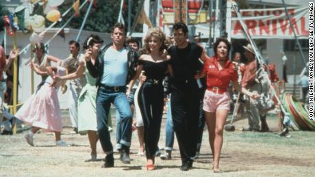 Jeff Conaway, Olivia Newton-John, John Travolta and Stockard Channing walk arm in arm at a carnival in a still from the film, &#39;Grease.&#39; 