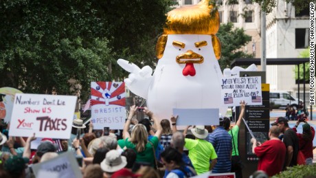 Demonstrators march through downtown Houston demanding greater governmental transparency and the release of President Donald Trump&#39;s tax returns during a protest Saturday, April 15, 2017. (Brett Coomer/Houston Chronicle via AP)