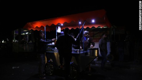 Customers visit a food stand in Gaza during an April 14 blackout.