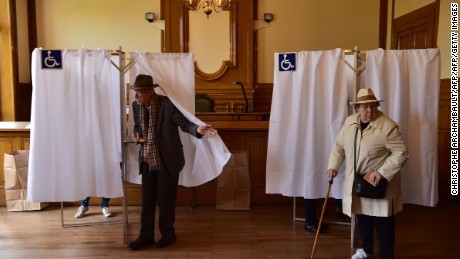 Voters leave their booths in the 7th district in Paris on Sunday to cast their ballots.