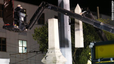 Workers use a crane to dismantle the Battle of Liberty Place monument early Monday morning.