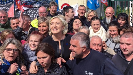 Le Pen  smiles with people in front of the Whirlpool factory in Amiens, northern France.